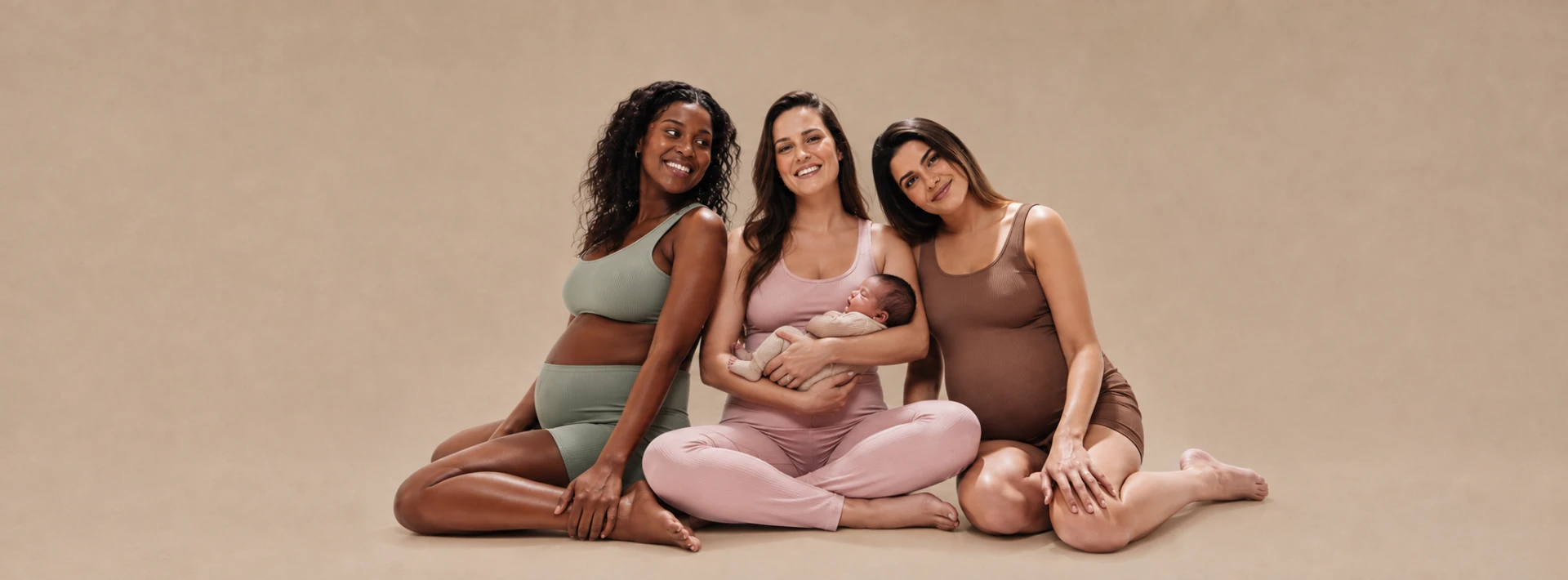 Deux femmes enceintes et une maman tenant son nouveau-né, assises ensemble au Studio Uma